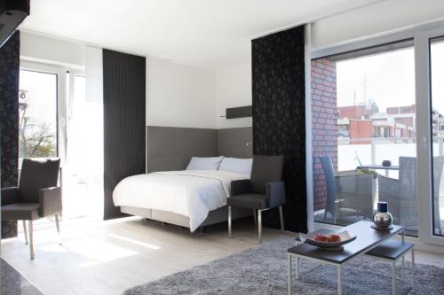 a bedroom with a bed and two chairs and a table at Refugium 1 in Emsdetten