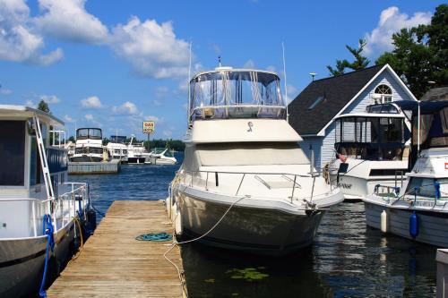 a boat is docked at a dock with other boats at The Ledges Resort & Marina in Alexandria Bay