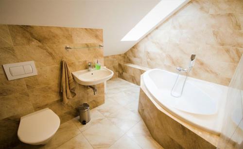 y baño con lavabo, bañera y aseo. en Penzion Na Americe, en Nové Jirny