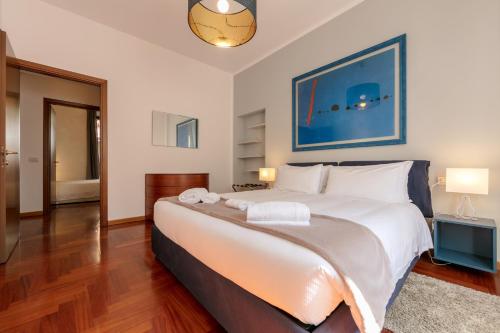una camera da letto con un grande letto con lenzuola bianche di Heart Milan Apartments Corso Como a Milano