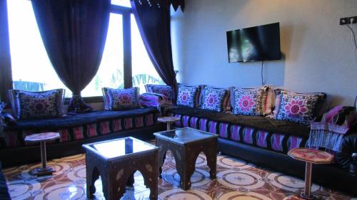 a living room with a couch and two tables at Villa La Zitoune in Aghmat