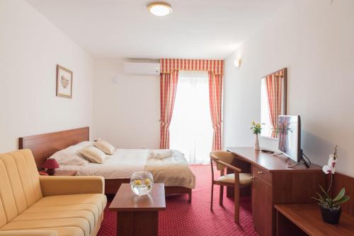 a hotel room with a bed and a desk at Hotel Krilo in Podstrana