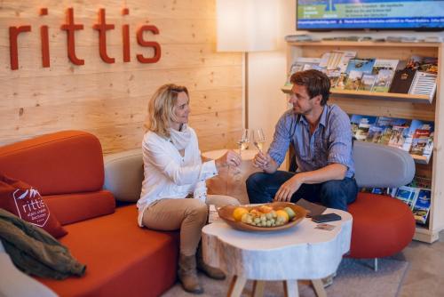 a man and woman sitting on a couch in a store at Rittis Alpin Chalets Dachstein in Ramsau am Dachstein
