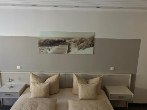 a bedroom with a couch with pillows and a picture on the wall at Pension Villa Transvaal in Ahlbeck