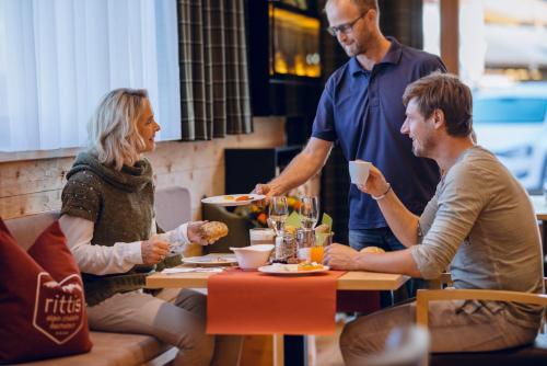 a group of people sitting at a table in a restaurant at Rittis Alpin Chalets Dachstein in Ramsau am Dachstein