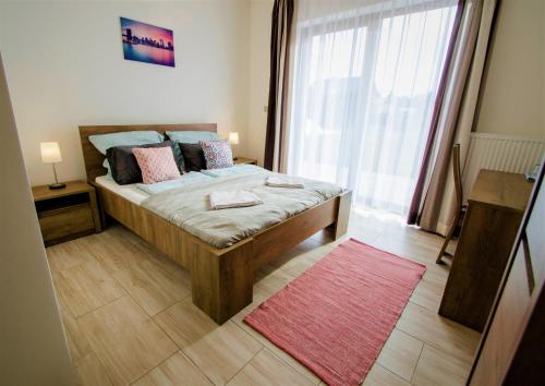 a bedroom with a bed and a large window at Penzion Na Americe in Nové Jirny