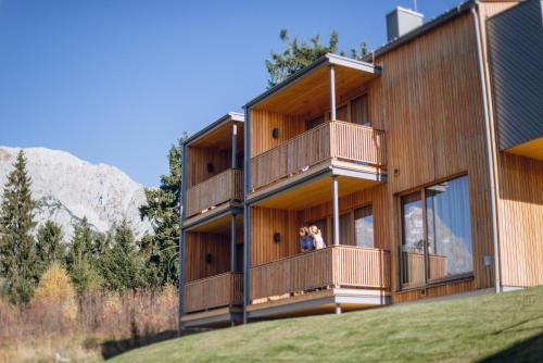 two people standing on the balcony of a building at Rittis Alpin Chalets Dachstein in Ramsau am Dachstein