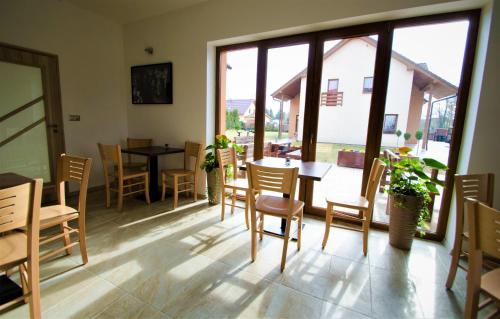 a dining room with a table and chairs and a window at Penzion Na Americe in Nové Jirny