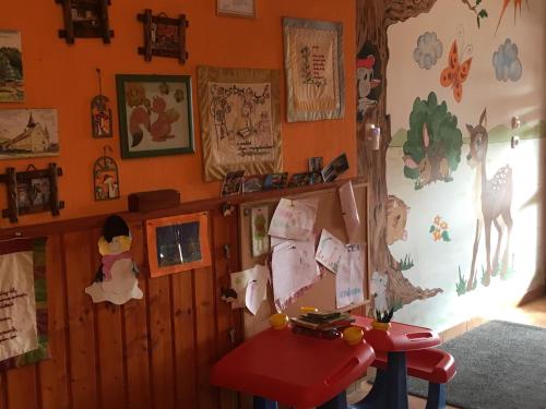 a room with a red table and some pictures on the wall at Bakonyi Apartmanház Eplény in Eplény