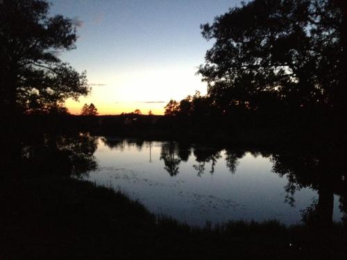 a sunset over a river with trees on the shore at Tråvad Nybo Lilla huset in Tråvad