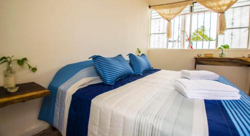 a blue and white bed with blue pillows on it at Casa Pancho Playa in San Francisco