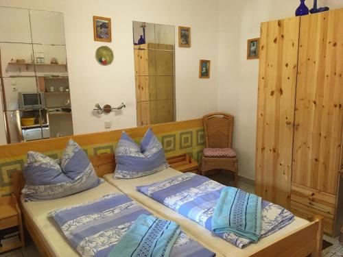 1 Schlafzimmer mit 2 Betten und blauen Kissen in der Unterkunft Bakonyi Apartmanház Eplény in Eplény