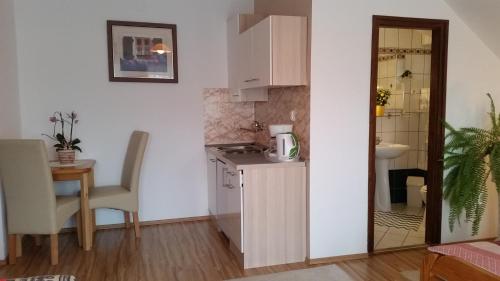 a small kitchen with a counter and a table at Majláth Vendégház in Bük