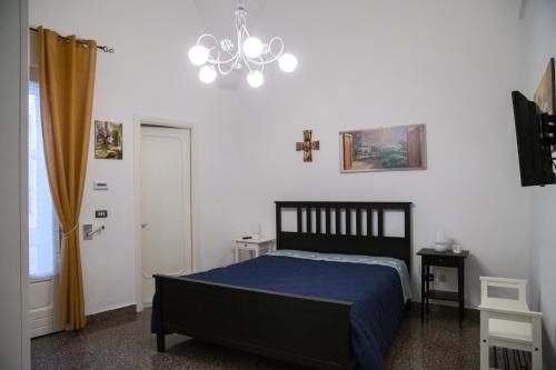 - une chambre avec un lit noir et un lustre dans l'établissement Da zia Concetta, à Campi Salentina