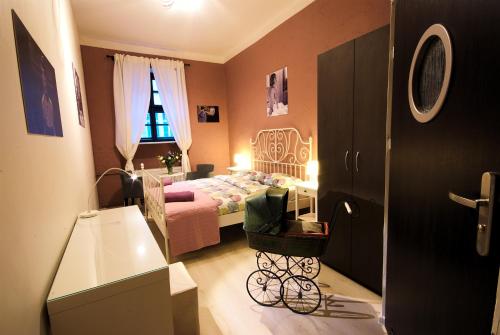 a small bedroom with a bed and a baby carriage at Rosemary's Private Ensuite Rooms in Old Town in Poznań