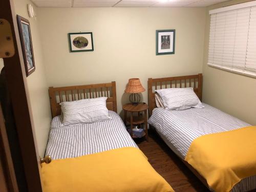 twee bedden in een slaapkamer met een lamp op een tafel bij Bear Cub Lodging in Jasper