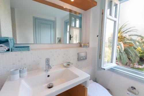 a bathroom with a white sink and a window at Alura Hotel in Alacati