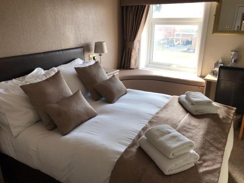 a bedroom with a white bed with towels on it at The Windsor Carlton in Blackpool