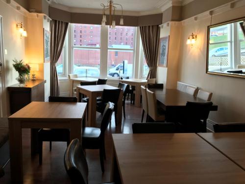 a restaurant with tables and chairs and a window at The Windsor Carlton in Blackpool