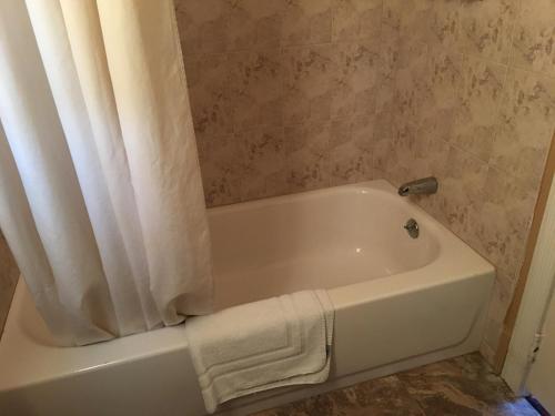 a bathroom with a white bath tub with a shower curtain at Budget Inn LAX-Lawndale in Lawndale