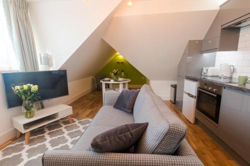 a living room with a couch and a kitchen at Broadstairs Apartments with luxurious 4-person communal hot tub - sleeps up to 20 people in Broadstairs