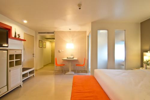 a bedroom with a bed and a table and chairs at Sunshine Vista Hotel in Pattaya Central