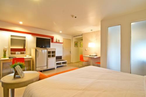 a hotel room with a bed and a kitchen at Sunshine Vista Hotel in Pattaya Central