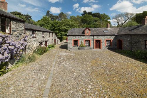 una vieja casa de piedra en un camino de grava en Conwy Valley Cottages en Conwy