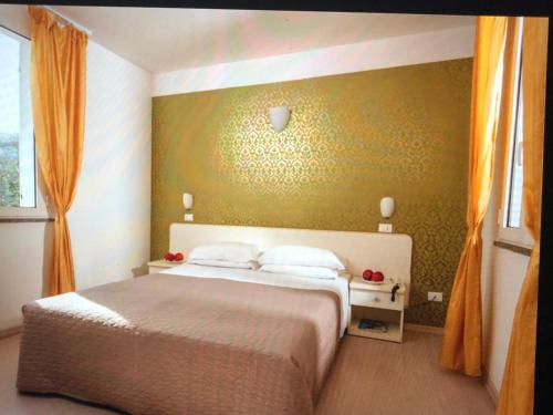 um quarto com uma cama grande e uma parede verde em Hotel Stella Polare em Rimini