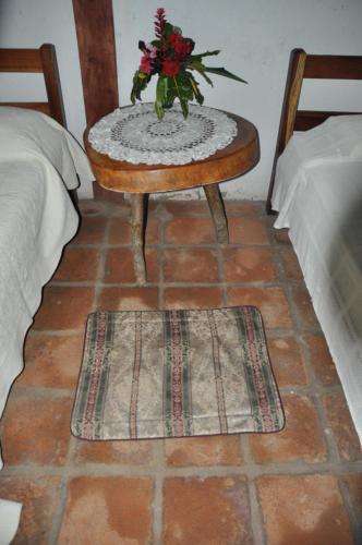 a table with a vase of flowers on it next to two beds at Hotel Ecológico Tierra Blanca in Moyogalpa