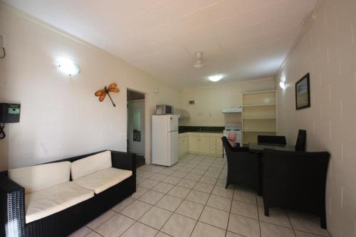 a living room with a couch and a kitchen at Coconut Grove Holiday Apartments in Darwin