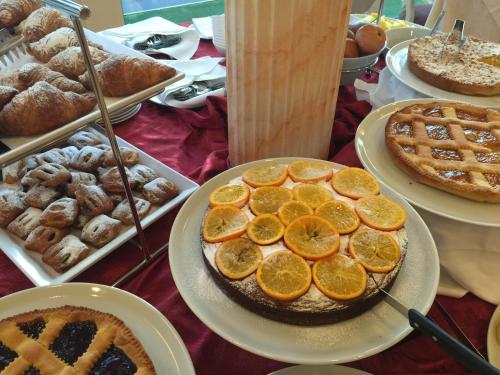 a table topped with pies and other pastries and cakes at Hotel Stella Polare in Rimini