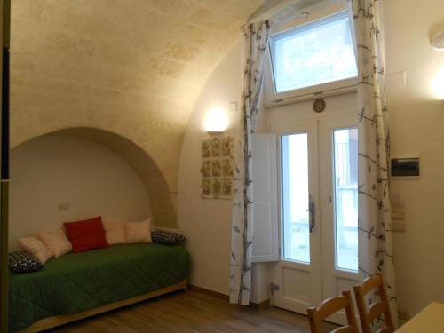 a bedroom with a green bed and a window at Il Trifoglio in Matera