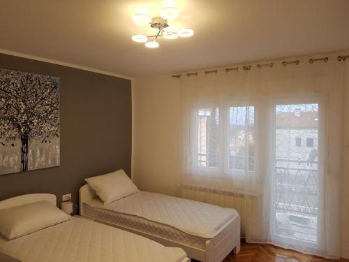 a bedroom with two twin beds and a window at App Sandra 3 bedrooms on 112m2 Kostrena in Šodići