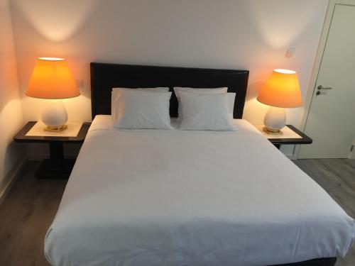 a bedroom with a large white bed with two lamps at Quinta BEMBOA Turismo Espaço Rural in Aricera