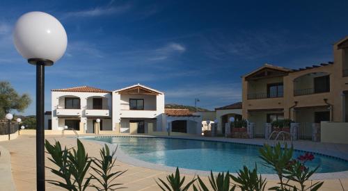 une villa avec une piscine et un éclairage de rue dans l'établissement Villaggio Turchese, à Murta Maria