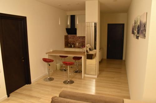 a living room with a table and red chairs at SaBa Apartments in Old Tbilisi in Tbilisi City