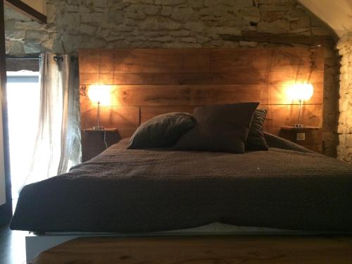 um quarto com uma cama grande e 2 candeeiros em La Maison Du Meunier em Loze