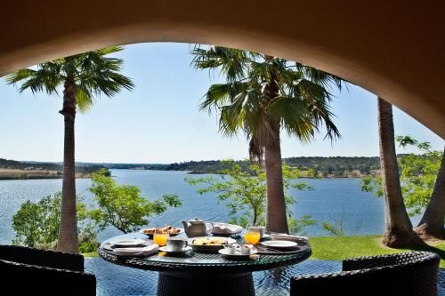 a table with food and a view of the water at Montargil Monte Novo in Montargil