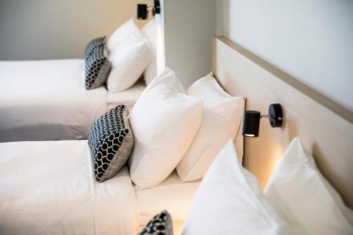 a bedroom with white pillows on a bed at Nightcap at Finsbury Hotel in Adelaide