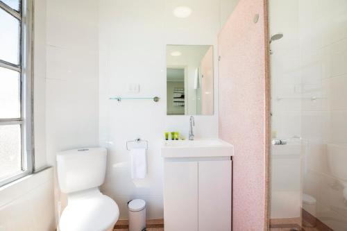 a white bathroom with a toilet and a sink at Nightcap at Finsbury Hotel in Adelaide
