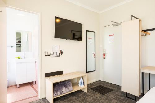 a room with a mirror and a tv on the wall at Nightcap at Finsbury Hotel in Adelaide