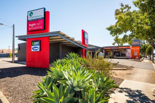 a gas station with a red sign in front of it at Nightcap at Finsbury Hotel in Adelaide