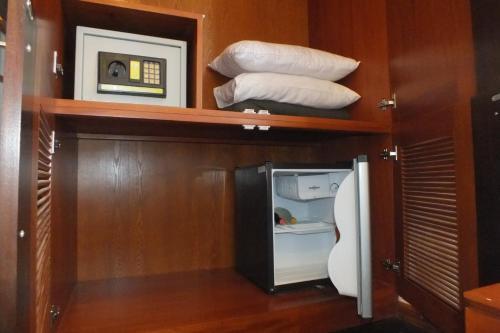 a small kitchen with a refrigerator and some pillows at Hotel Topaz in Kandy