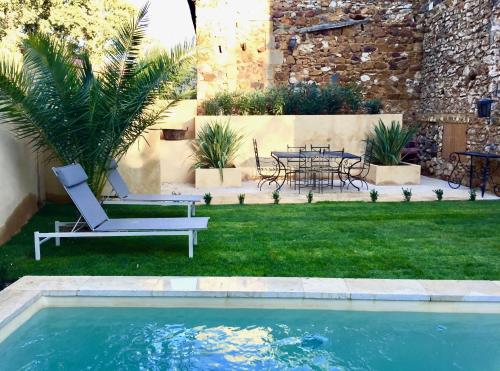 a yard with a pool and a table and chairs at XIXe Provencal Stone House with Private Pool near Uzes in Uzès
