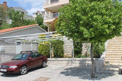 a car parked in a parking lot next to a house at Apartments Mareblu in Rabac
