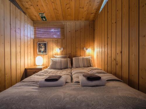 a bedroom with a large bed in a wooden wall at Lovely Cabin in the Capital Area with hot tube in Hafnarfjördur