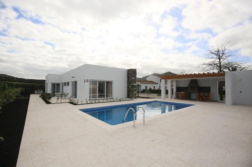 una casa con piscina frente a ella en Quinta das Giestas, en Ribeira Grande