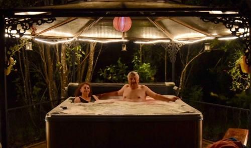a man and a woman sitting in a bath tub at Cabañas Natural Park Lodge Pucón in Pucón