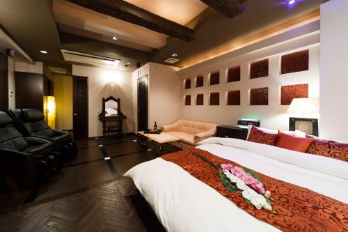 ein Schlafzimmer mit einem großen Bett und einer Couch in der Unterkunft HOTEL MYTH M -ホテル マイス エム- Adult Only in Sennan